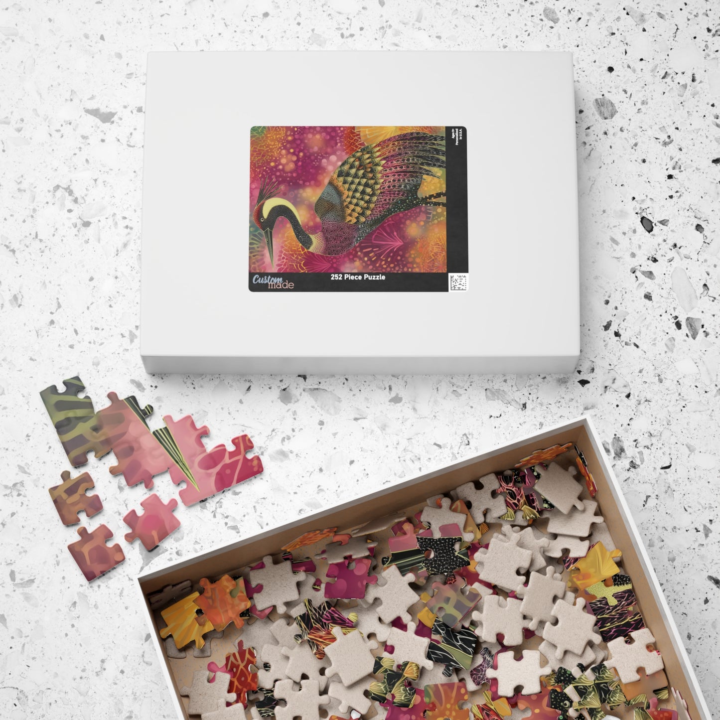 Jigsaw puzzle set with a box of partially completed puzzles on a speckled surface