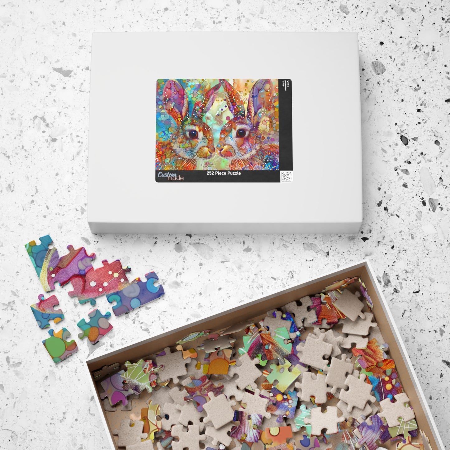 Colorful puzzle with completed pieces and a box on a textured surface
