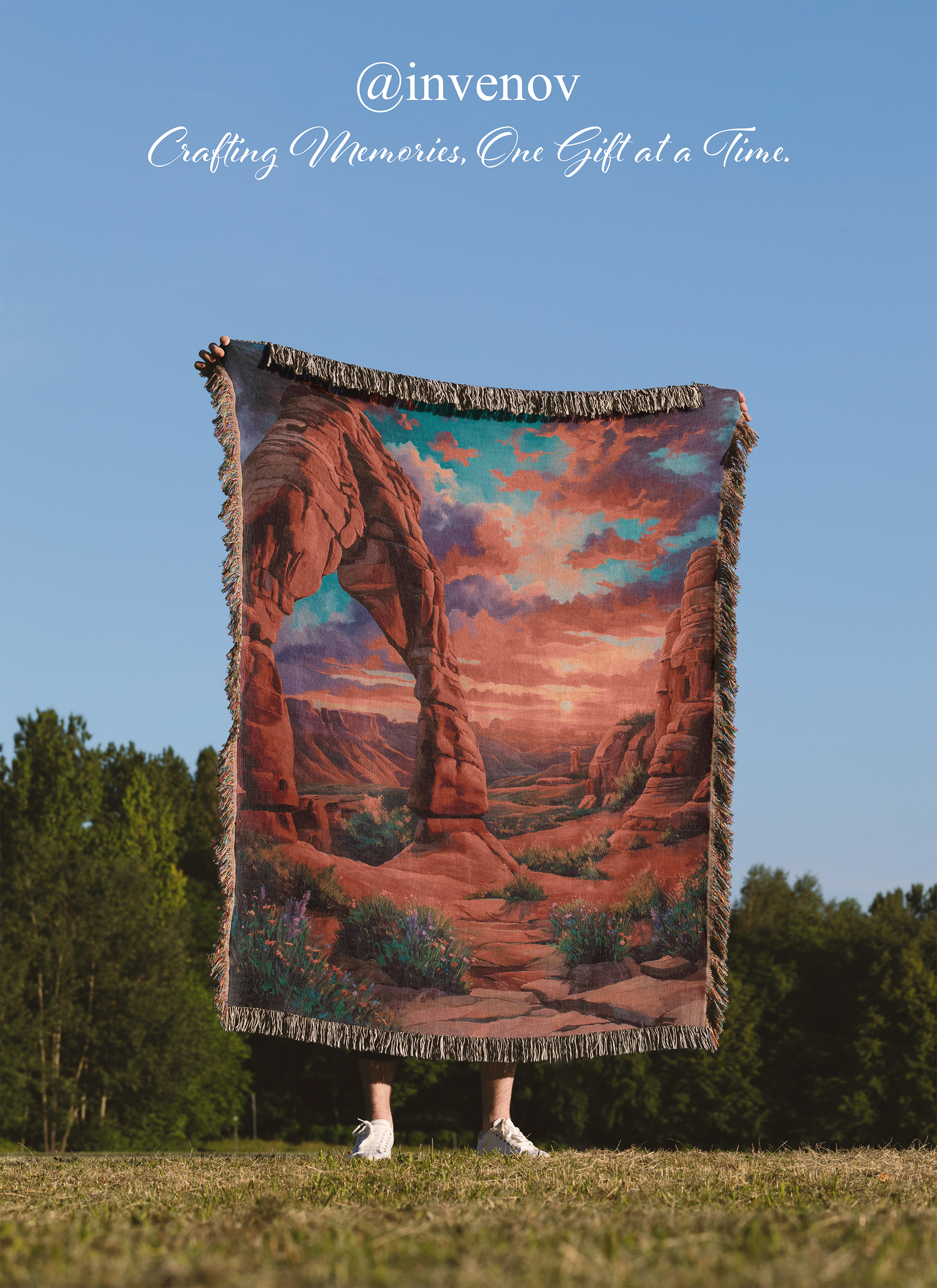Person holding a scenic blanket with desert landscape design outdoors