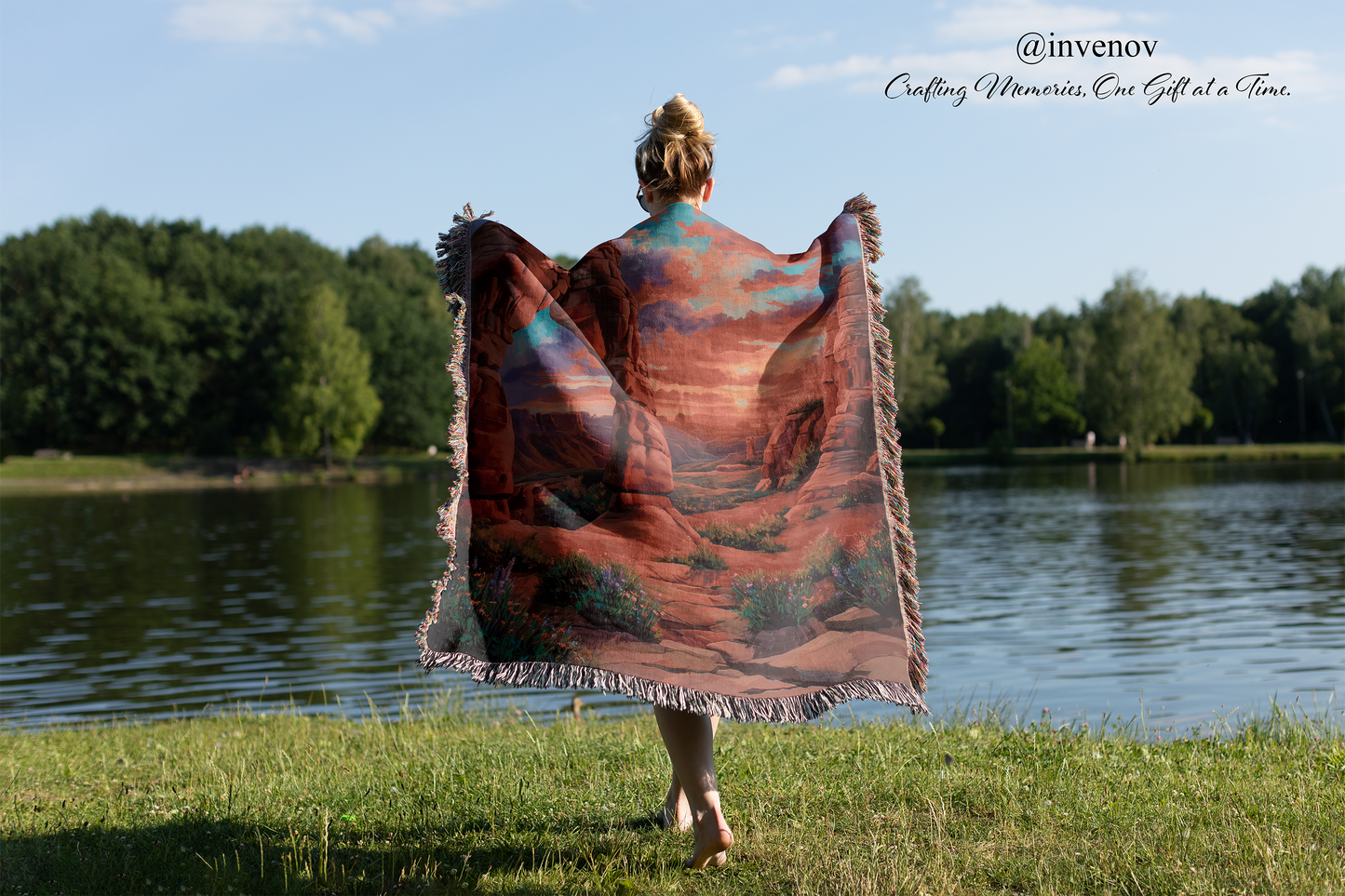 Person holding a colorful blanket by a lake