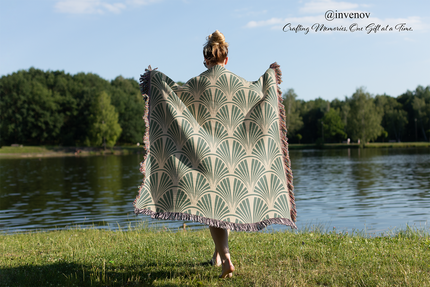 Person holding a patterned blanket by a lake with 'invenov' branding.
