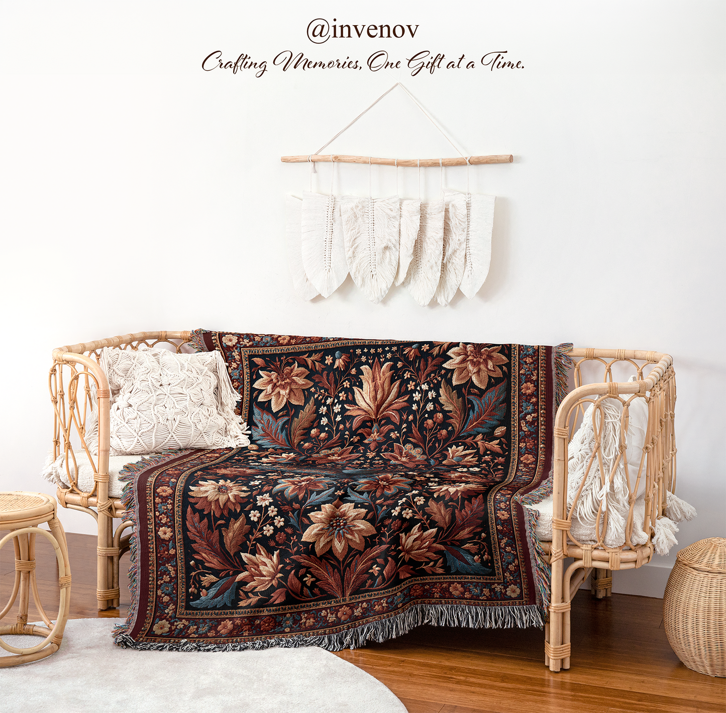 A bohemian-style woven rattan daybed draped with a dark brown and beige floral patterned throw blanket, styled in a bright room with a macrame wall hanging and wooden floor.