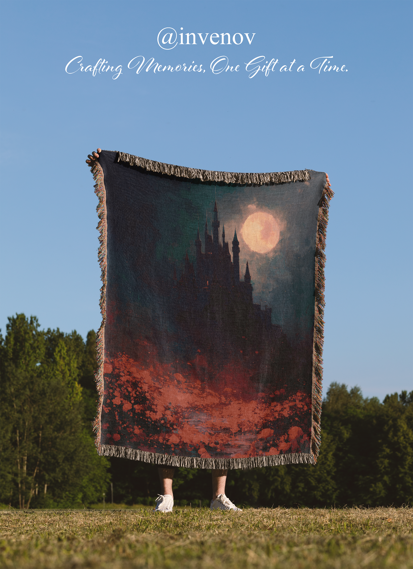 Person holding a blanket with a castle design against a blue sky.