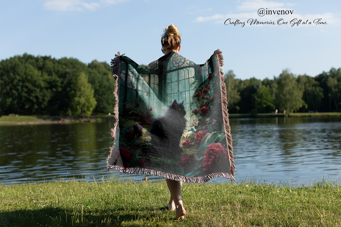 Person holding a decorative blanket with floral patterns by a lake