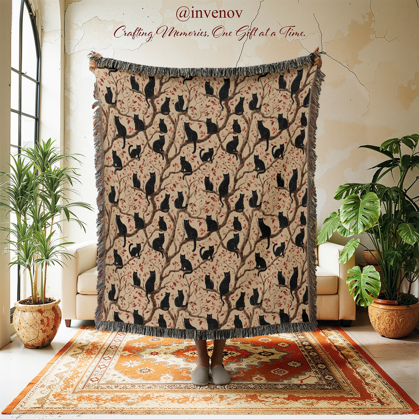 Decorative blanket with black cat pattern draped over a person in a room with plants and a rug.