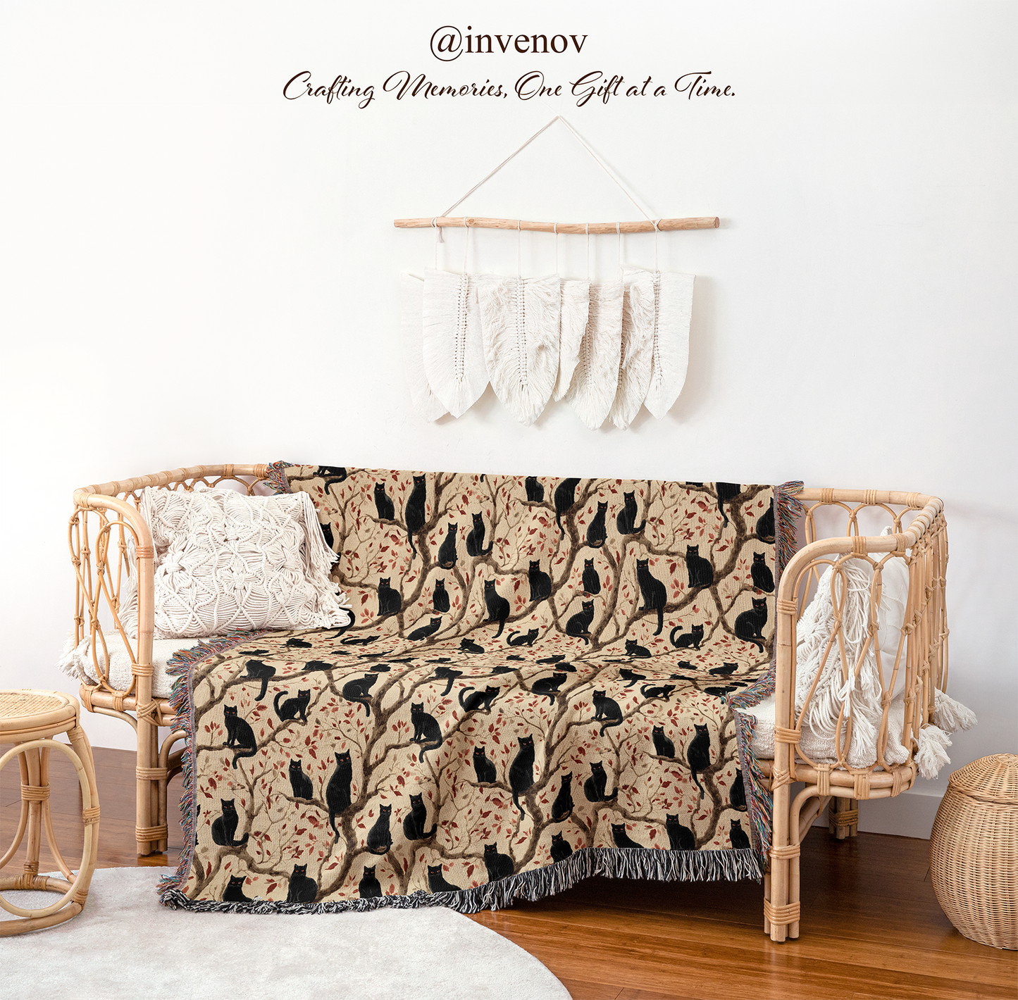 Decorative blanket with black cat pattern draped over a wicker chair