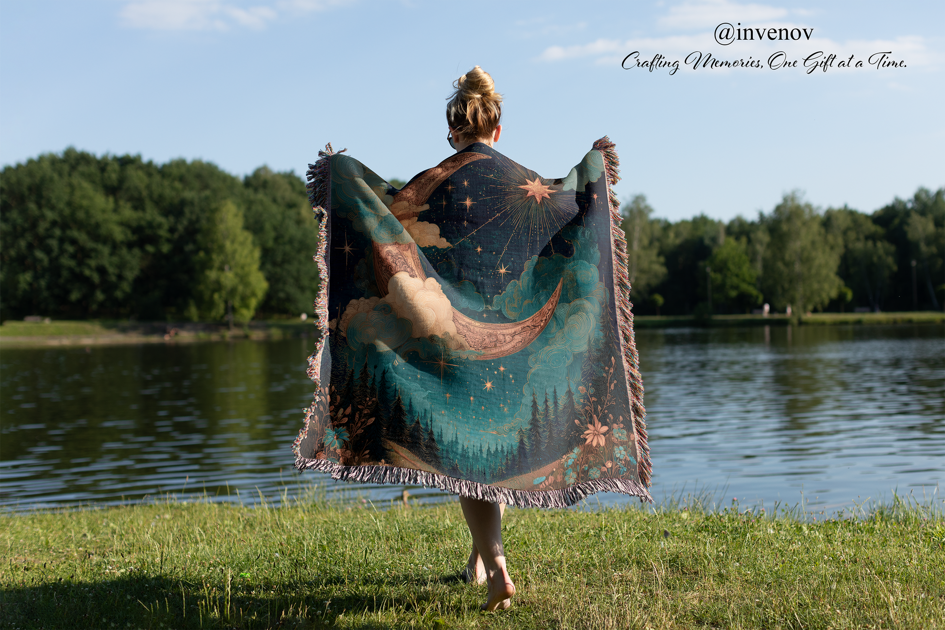 Person holding a colorful blanket with nature design by a lake
