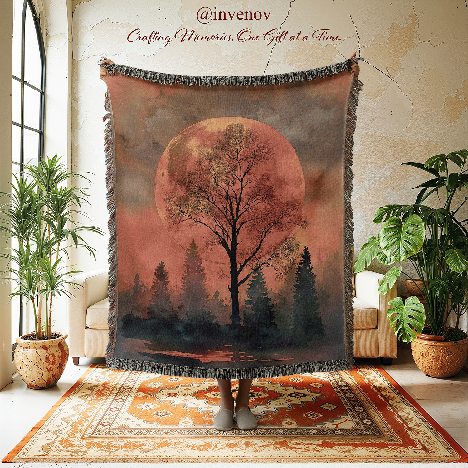 Decorative tapestry with a tree and moon design in a room with plants and furniture.
