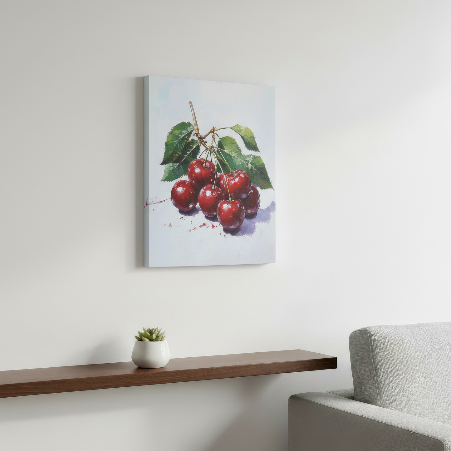 Canvas print of cherries on a wall above a wooden shelf with a plant and a gray chair.