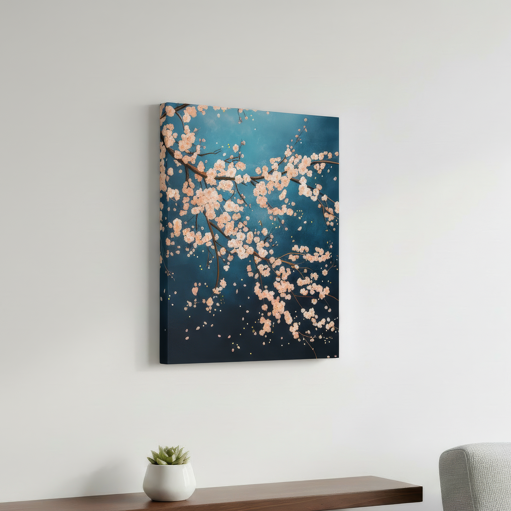 Wall art with floral design on a white wall above a shelf with a plant and gray sofa.