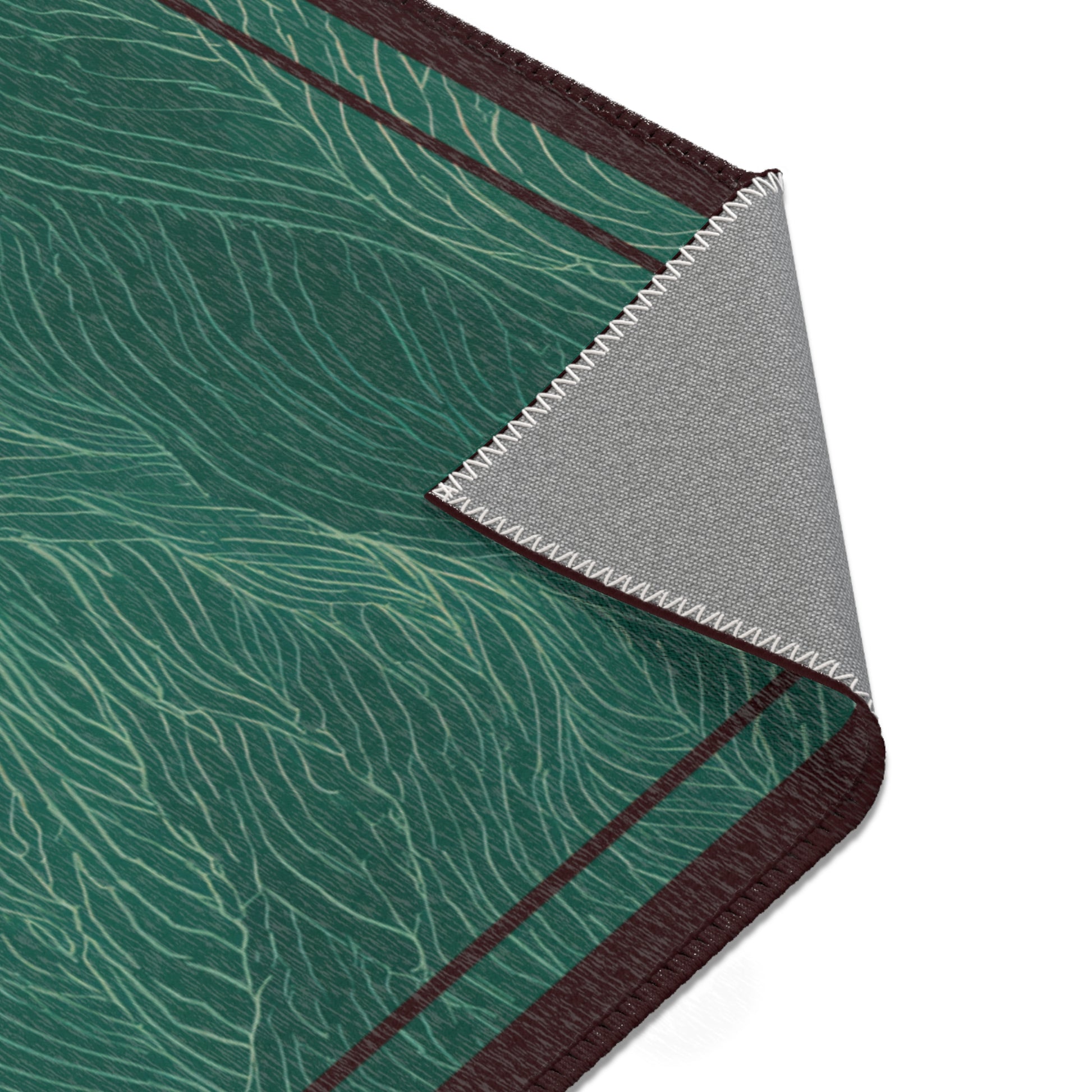 Close-up of a rug with green wavy pattern, brown border, and gray background.