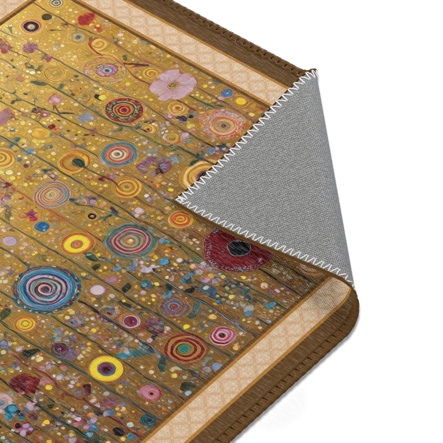 A close-up of a decorative rug or mat with a gold-toned background and many colorful circular and floral motifs, shown with one corner folded back to reveal a gray underside.