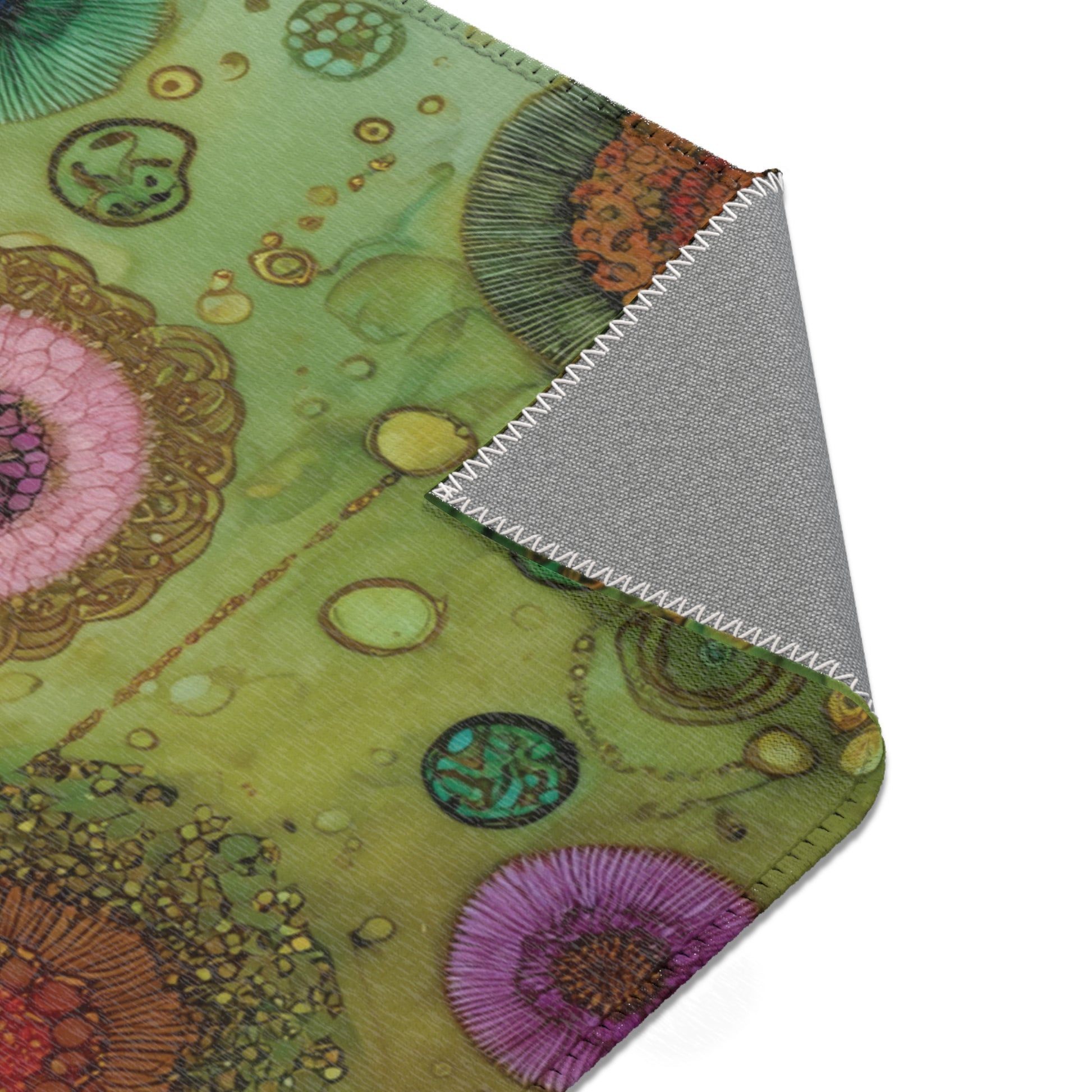Close-up of a area rug with a colorful floral pattern on a green background.
