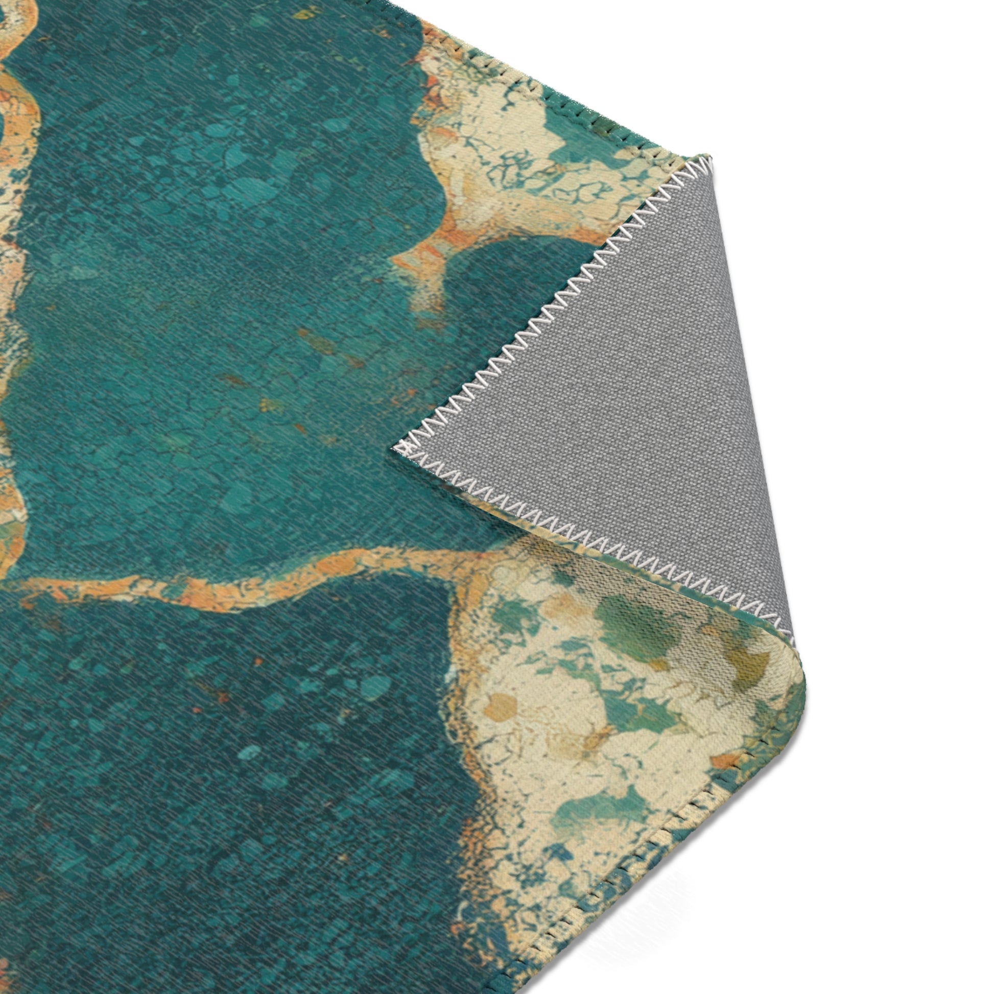 Close-up of a textured rug with a mix of teal, gold, and gray colors on a white background.