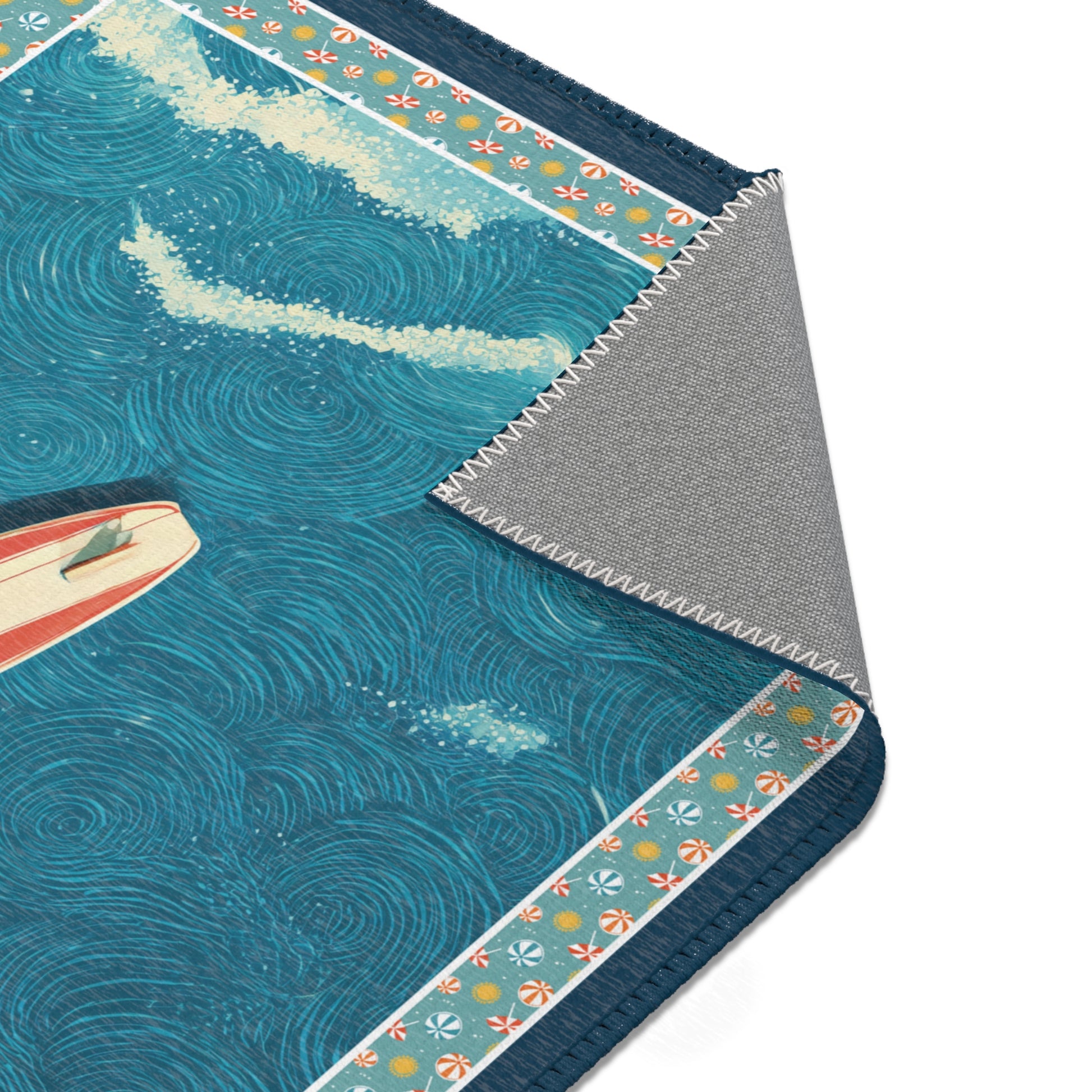 Close-up of a rug with ocean design featuring a surfboard and wave patterns.