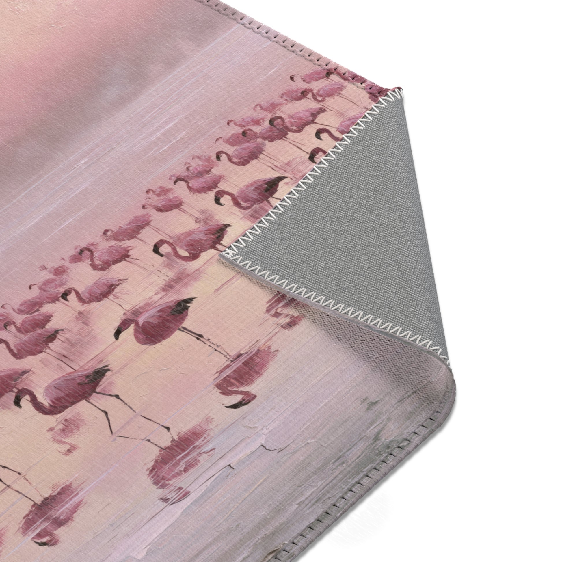 Close-up of an area rug with flamingo pattern on a pink background