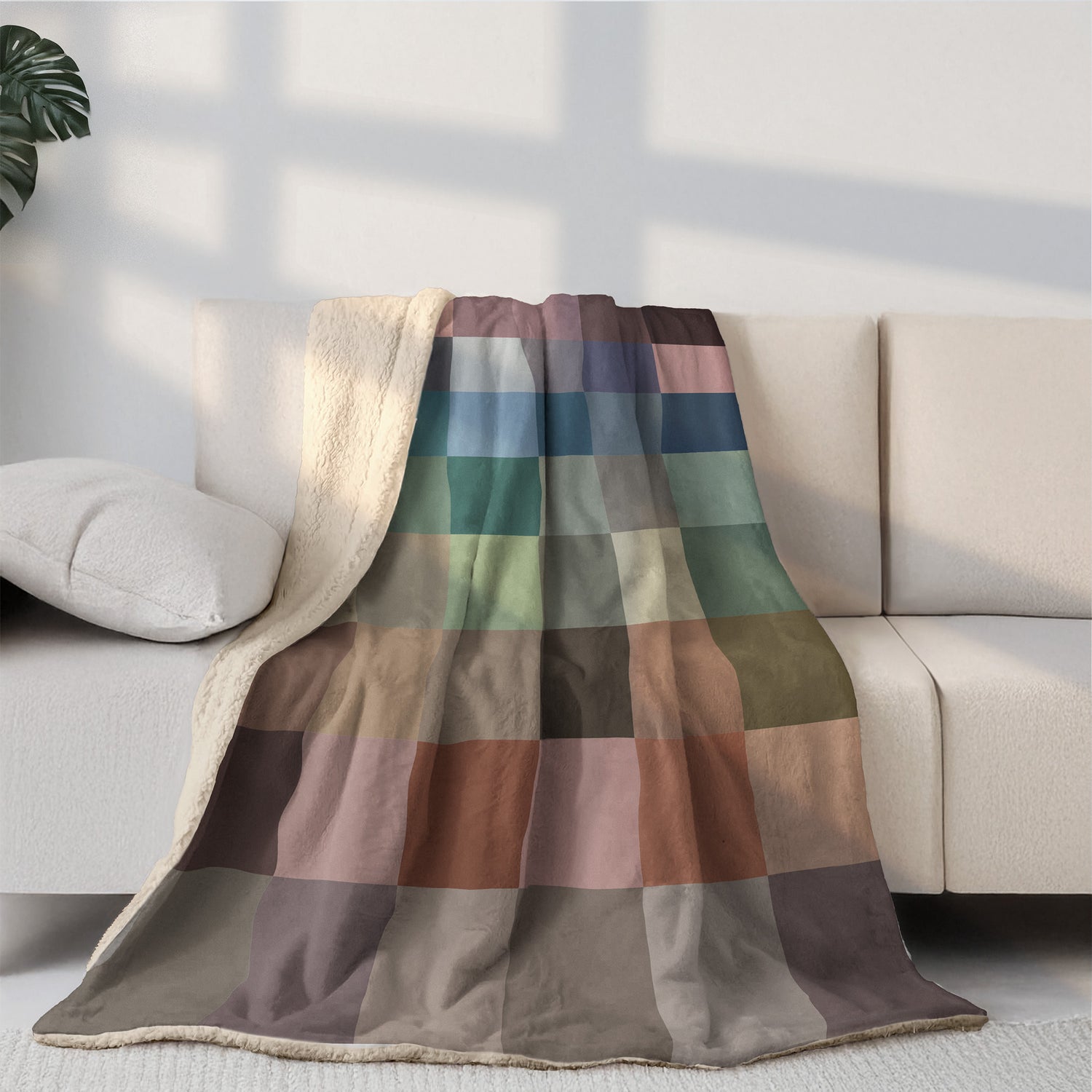Colorful checkered blanket draped over a beige sofa in a living room setting.