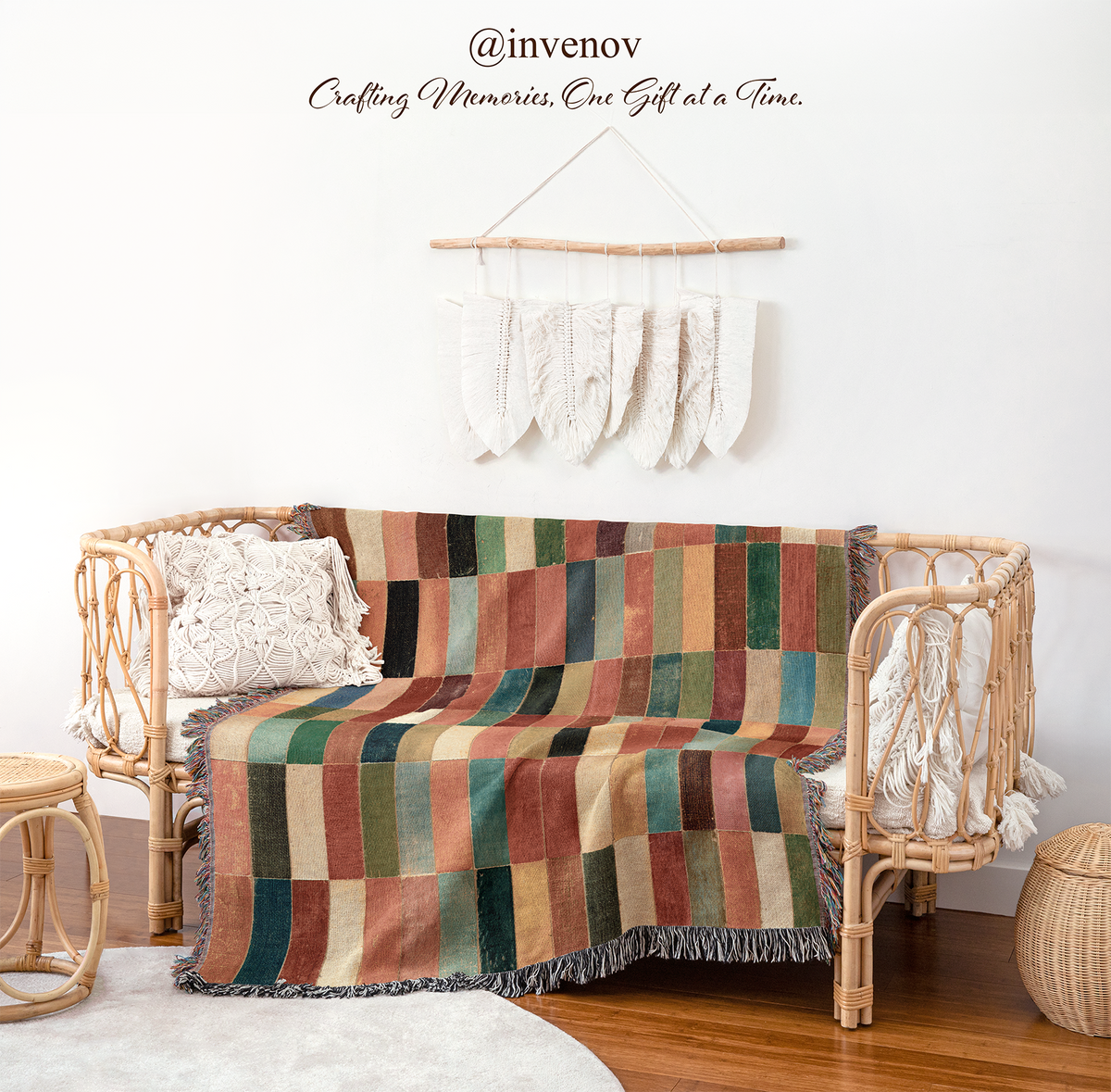 A woven rattan daybed with a multicolor patchwork striped throw blanket draped over it, styled in a warm, bohemian room setting with a white wall, decorative wall hanging, and wooden floor.