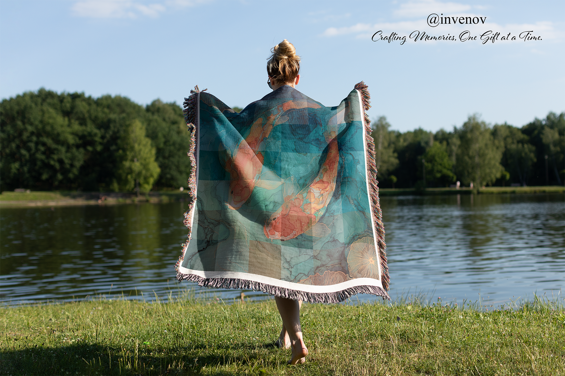 Person holding a colorful blanket by a lake with trees in the background