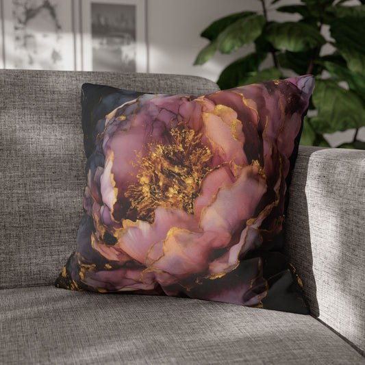 A square throw pillow featuring a large, artistic peony print in shades of dusty pink, purple, and gold, resting on a gray textured sofa in a living room setting.
