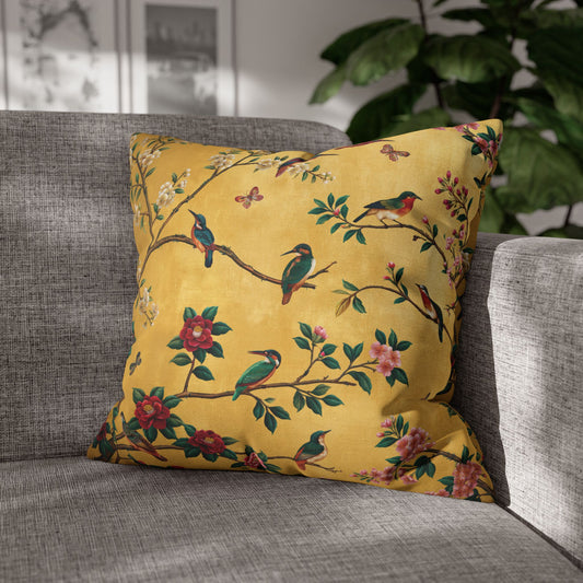 Yellow decorative pillow with bird and floral pattern on a gray sofa