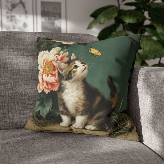 Decorative pillow with a kitten and floral design on a gray sofa.