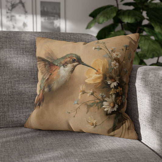 Decorative pillow with a hummingbird and floral design on a gray sofa.
