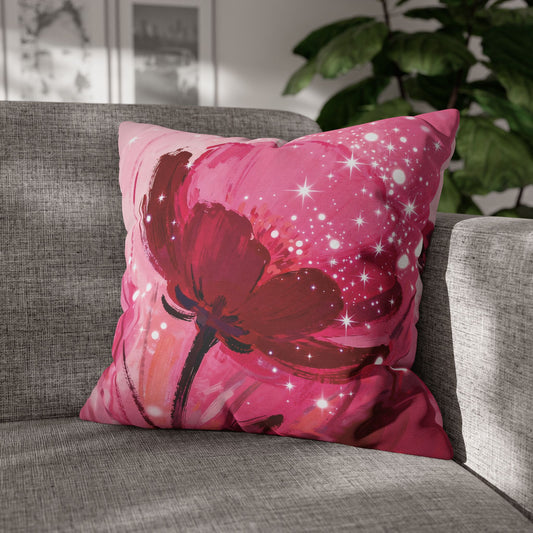 Pink pillow with a red floral design on a gray couch