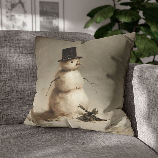 A square throw pillow featuring a vintage-style illustration of a snowman wearing a top hat, resting on a gray textured sofa in a living room setting.