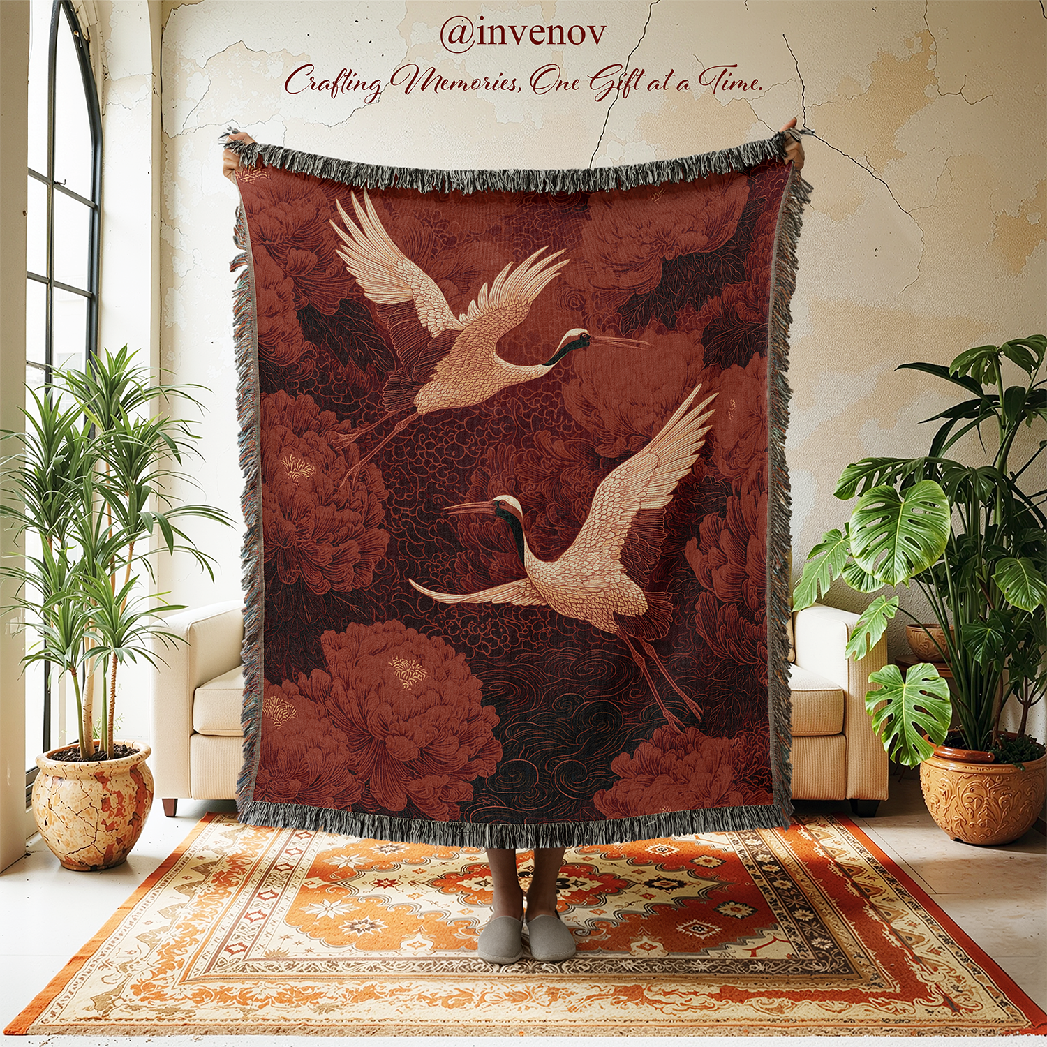 Decorative throw blanket with crane design in a room with plants and furniture.