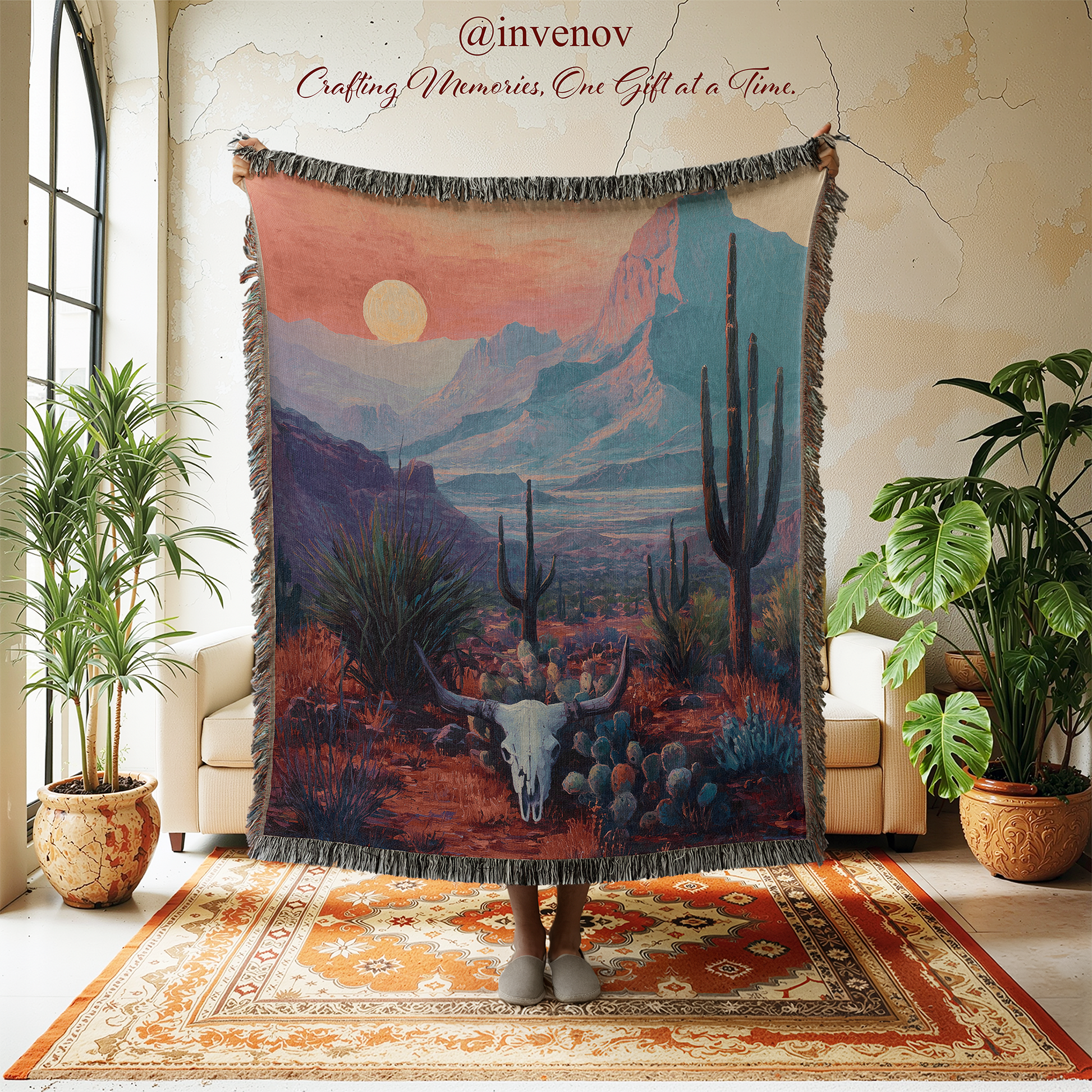 Woven tapestry of a desert scene with mountains and cacti in a room with plants and furniture.