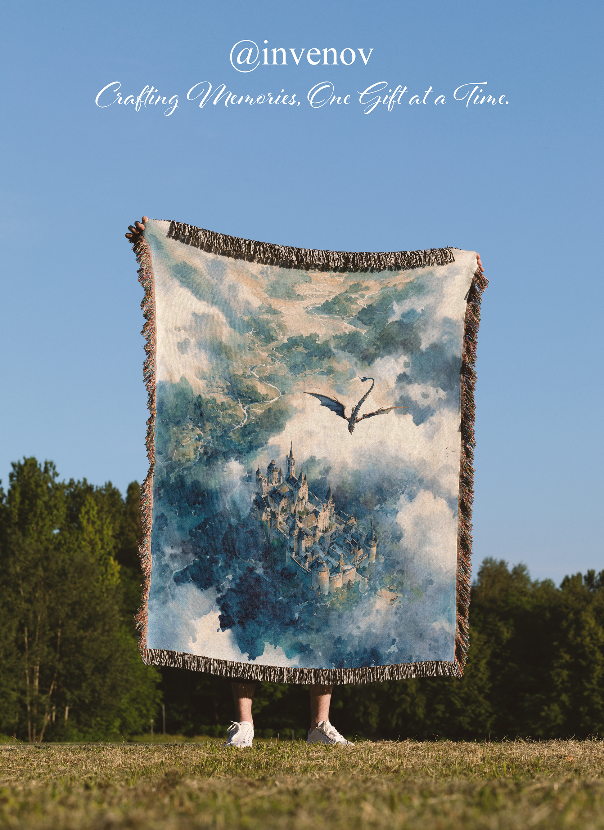 Blanket with a castle and dragon design held by a person in an open field with 'invenov' branding.