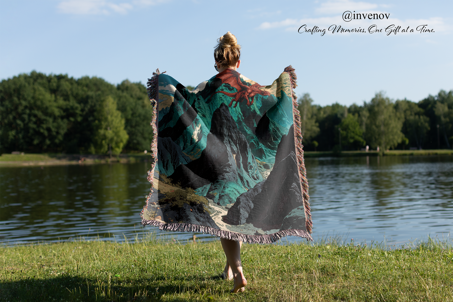 Person holding a colorful blanket by a lake with trees in the background