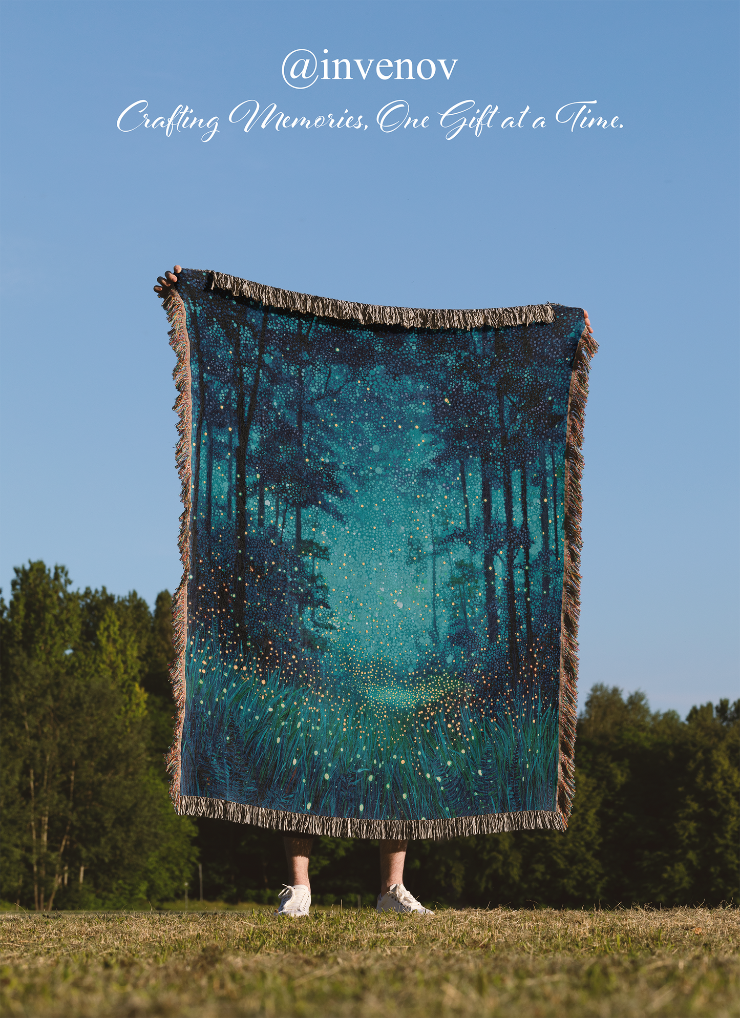 Person holding a large teal forest-themed blanket outdoors