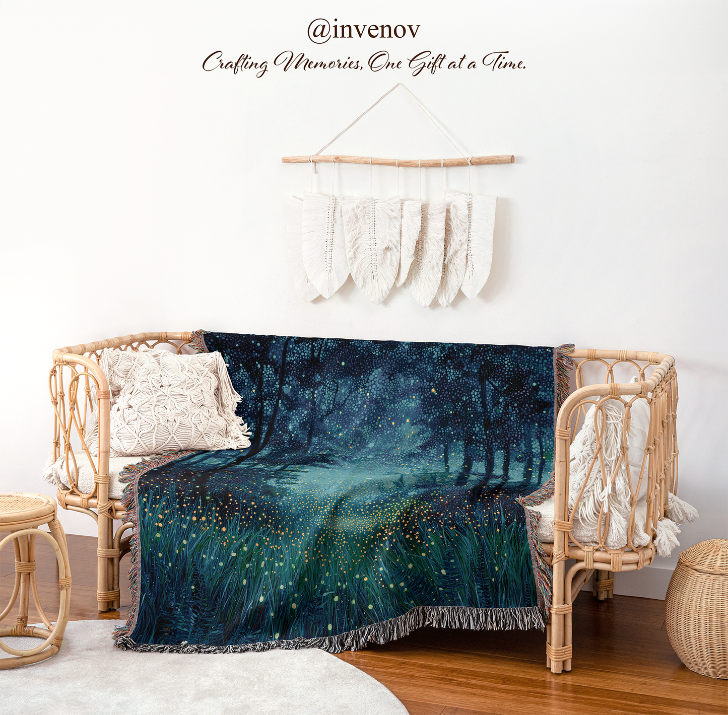 A cozy woven rattan daybed in a styled nursery or playroom setting, draped with a dark blue and teal blanket featuring a glowing forest and firefly pattern. The room features a white wall with a macrame wall hanging, a small wooden stool, and a light wood floor.