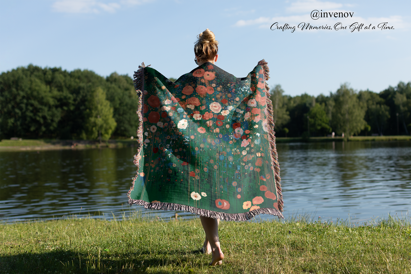 Person holding a floral-patterned blanket by a lake