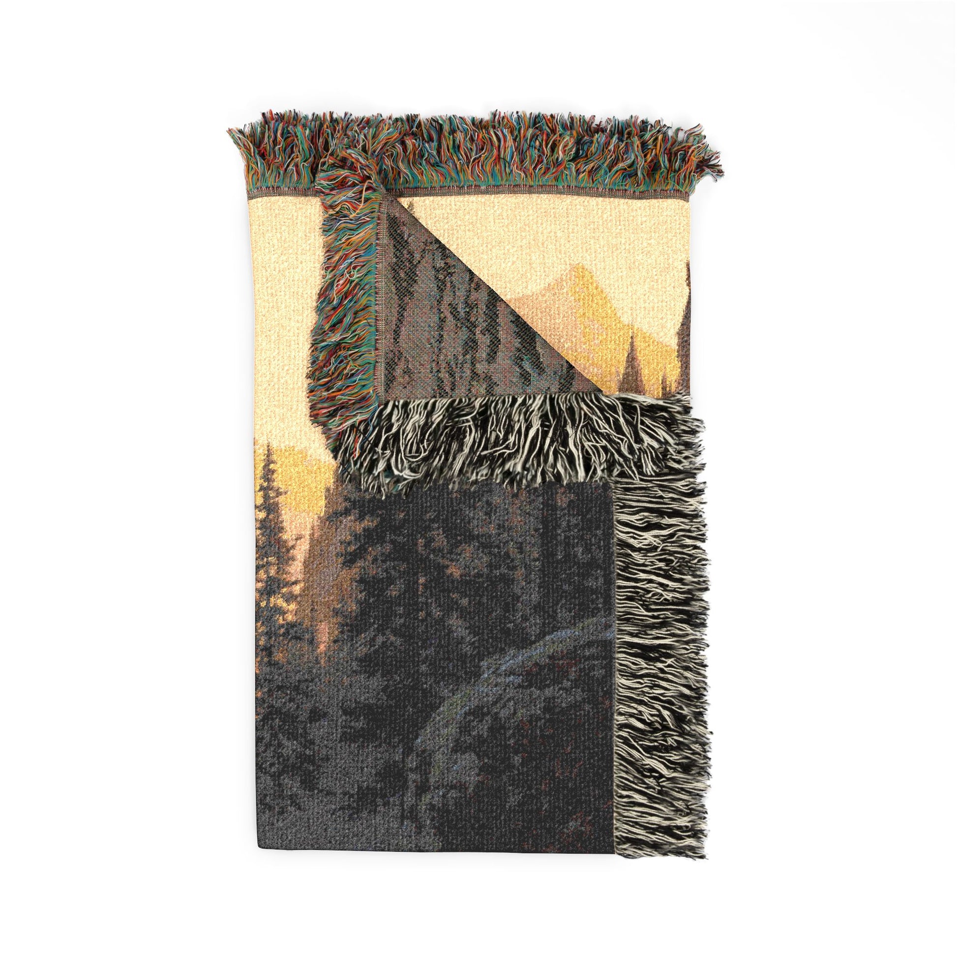 Woven blanket with mountain and forest design on a white background