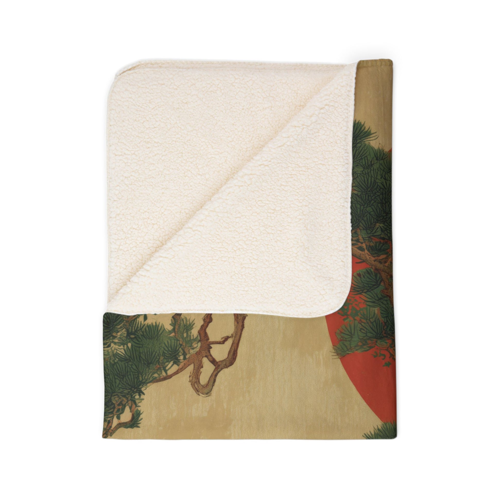Folded blanket with nature-themed design on a white background