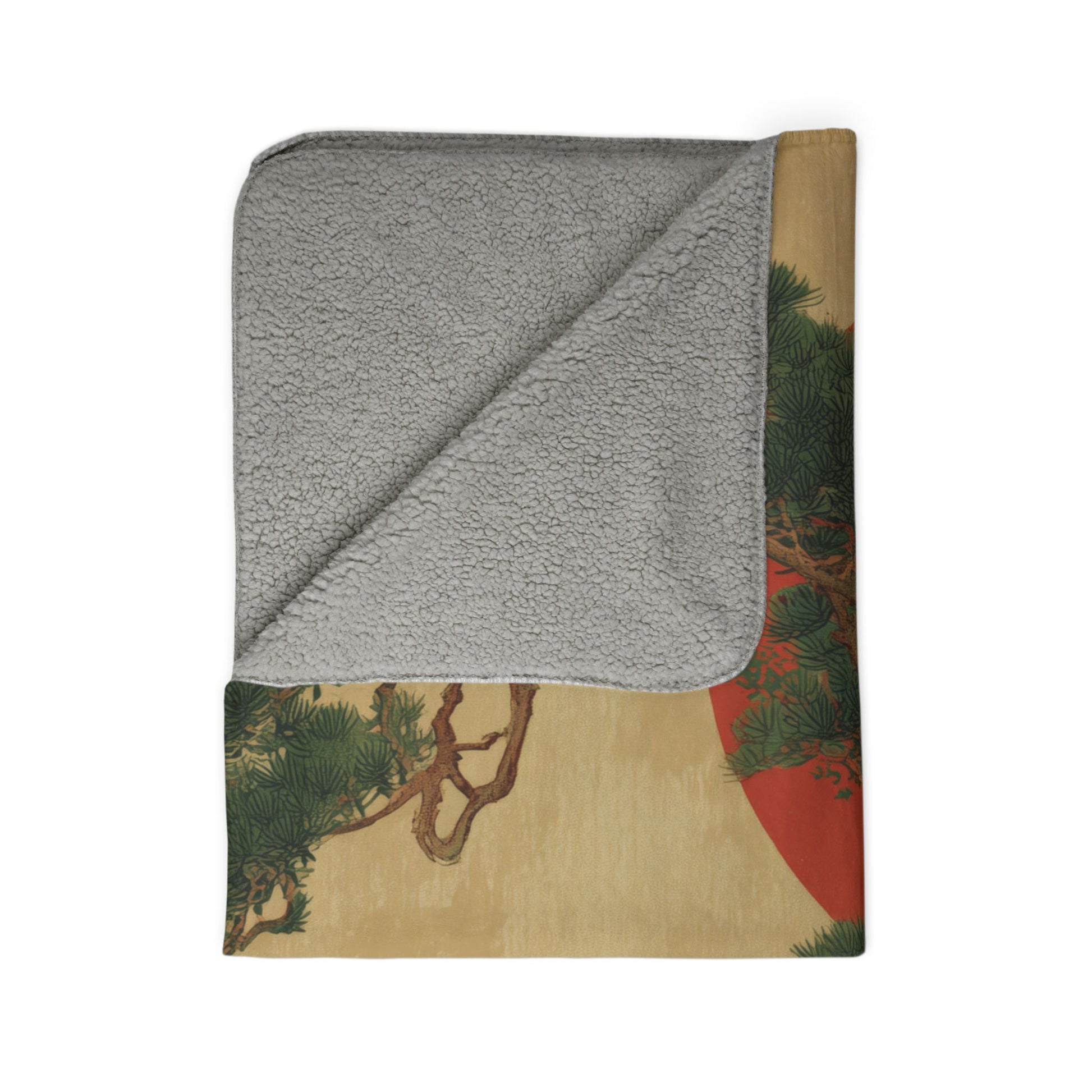 Folded blanket with gray fleece interior and colorful nature-themed exterior on a white background