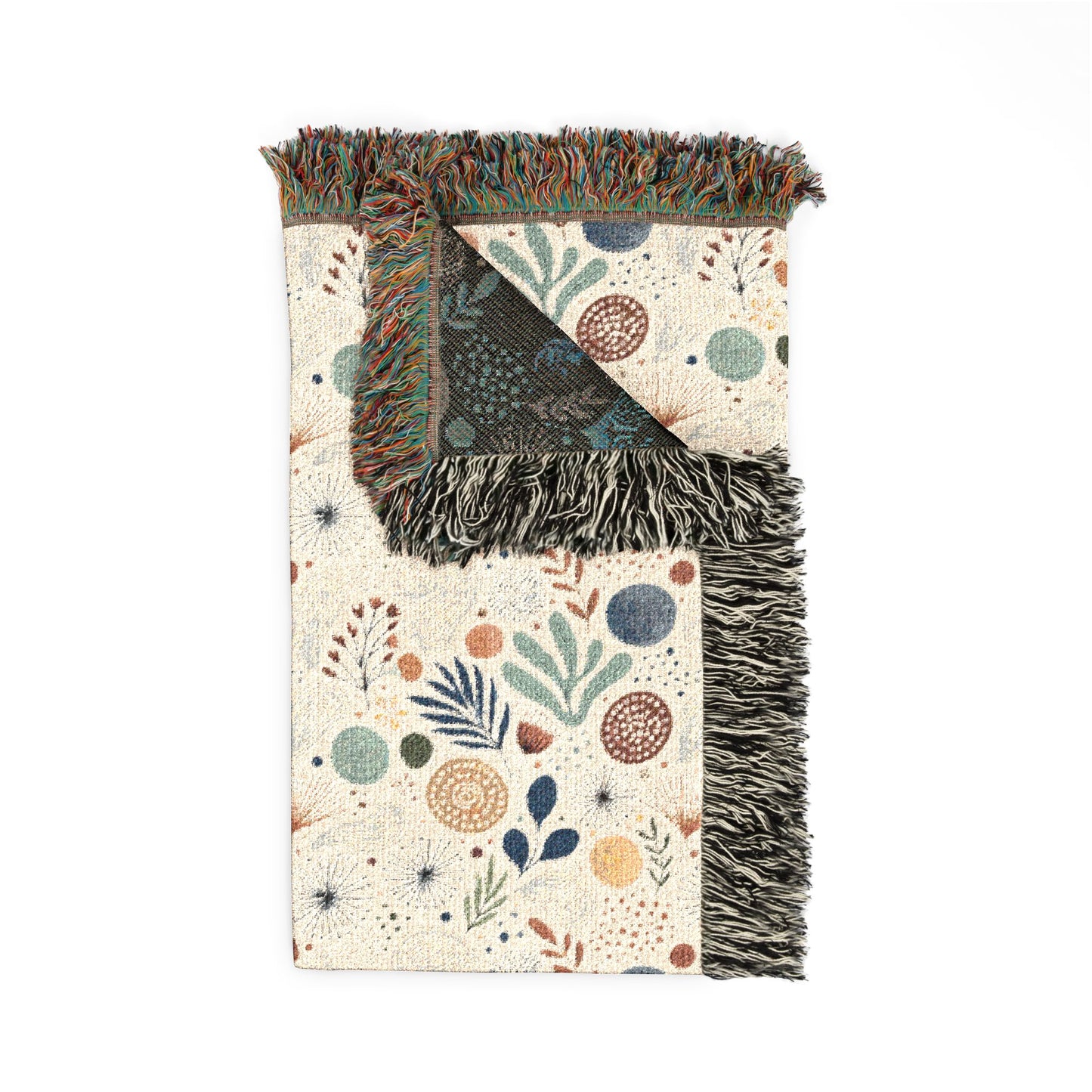 Decorative throw blanket with floral patterns and fringe on a white background