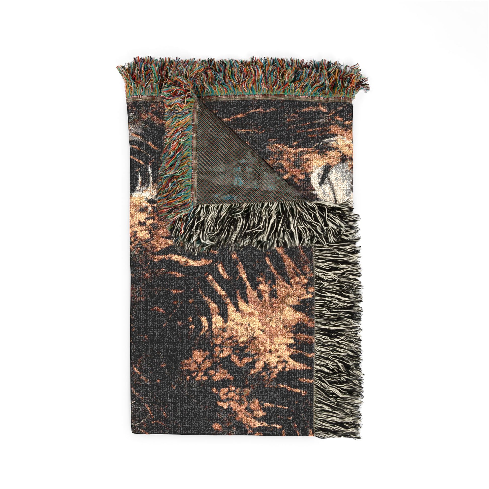 A folded woven throw blanket with multicolor fringe, featuring a distressed abstract pattern in black, brown, and beige tones, shown on a plain white background.