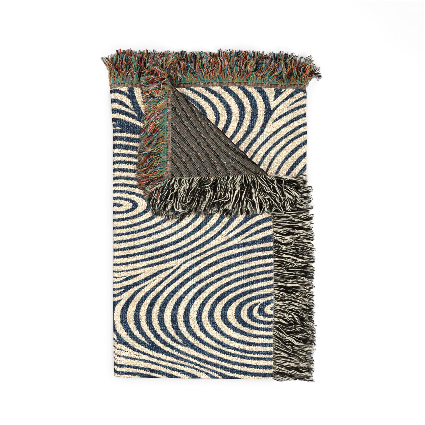A folded woven throw blanket with a navy blue and cream wavy spiral pattern, featuring multicolor fringed edges and a dark charcoal reverse side, shown on a plain white background.