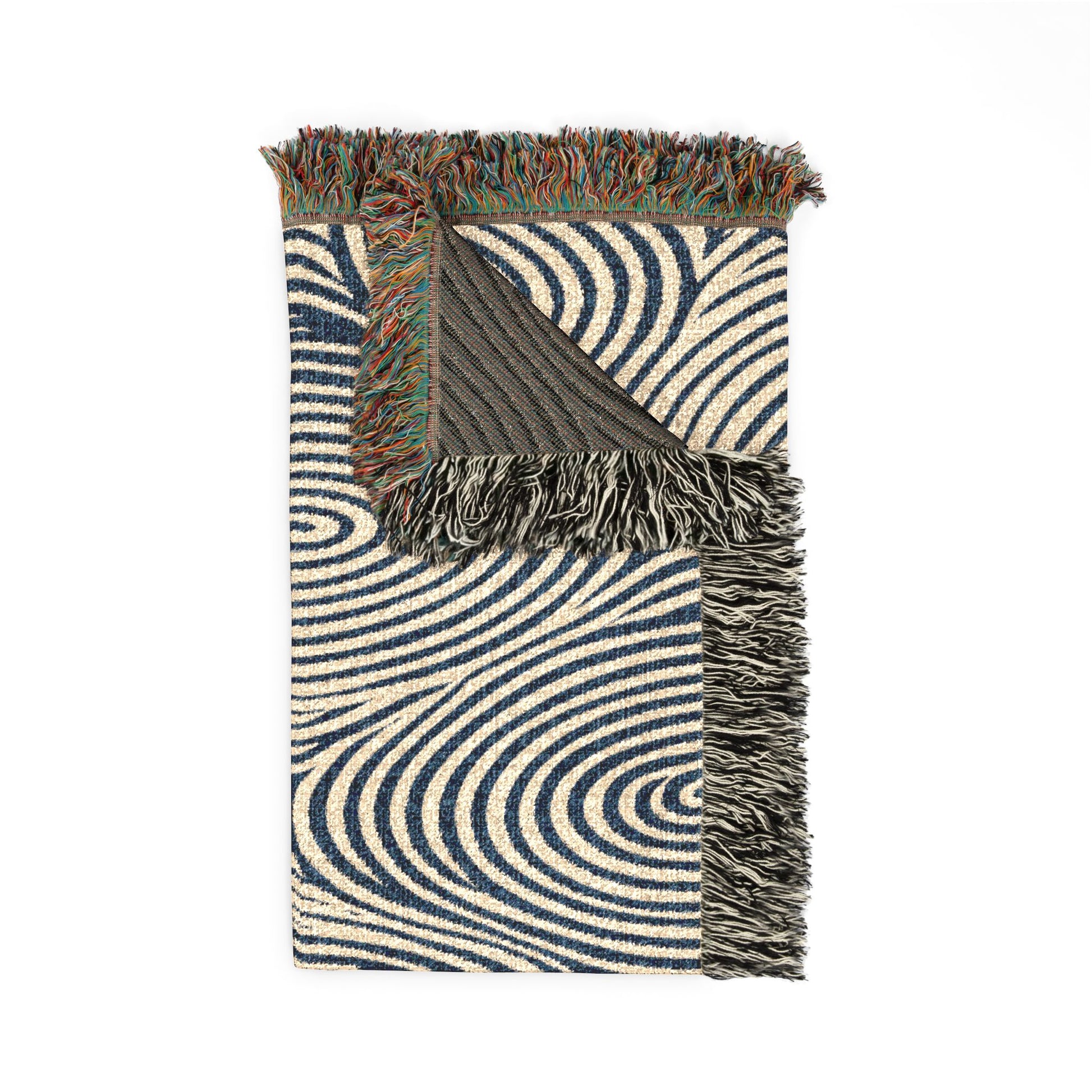 A folded woven throw blanket with a navy blue and cream wavy spiral pattern, featuring multicolor fringed edges and a dark charcoal reverse side, shown on a plain white background.