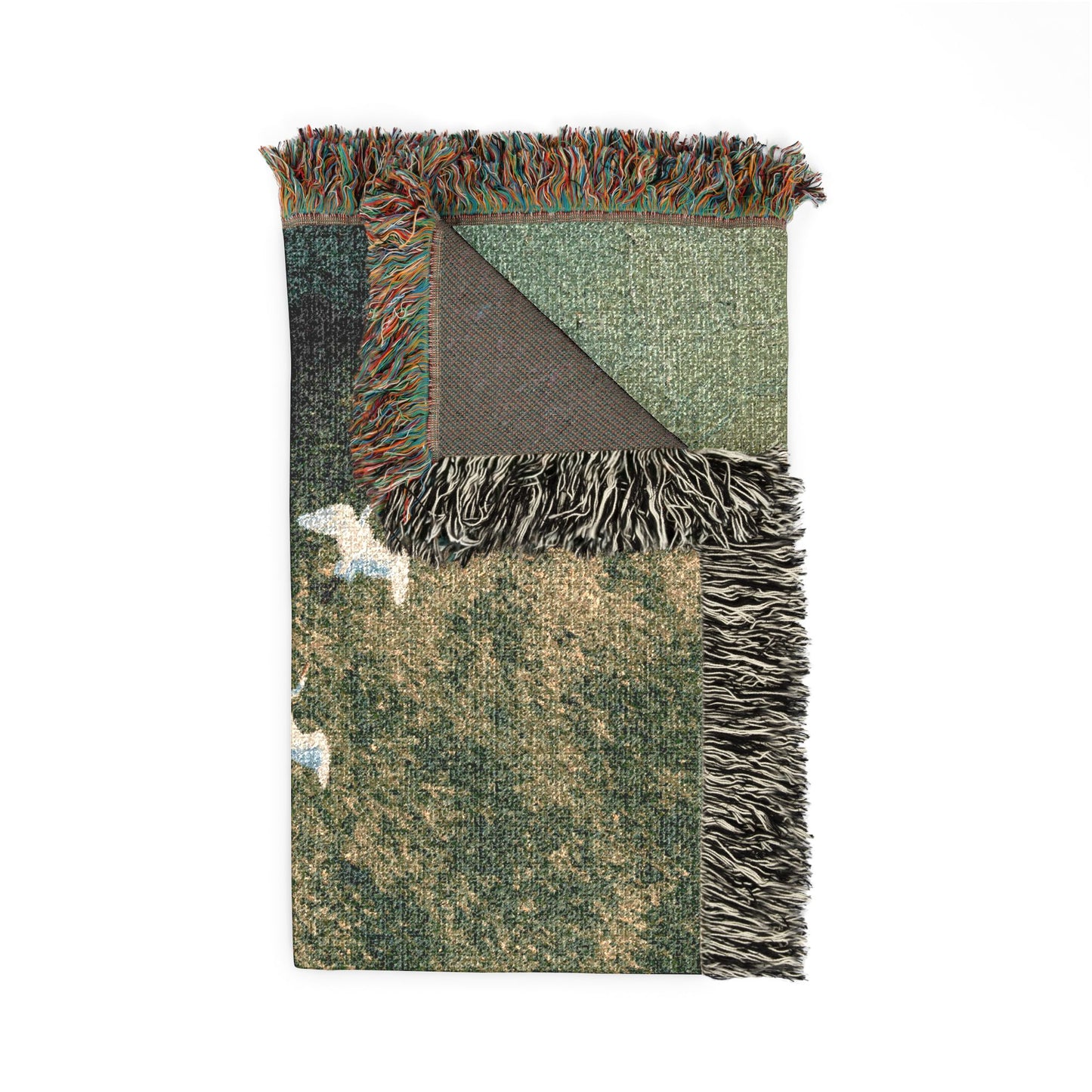 A folded woven throw blanket with multicolor fringe, featuring a textured pattern in shades of green, beige, and brown, with a dark brown underside showing the woven backing.