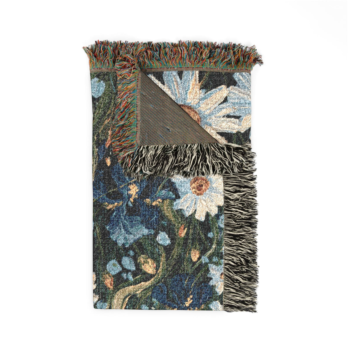 A folded woven textile with fringe, featuring a floral and botanical pattern in dark blue, cream, beige, and muted green tones, photographed on a plain white background.