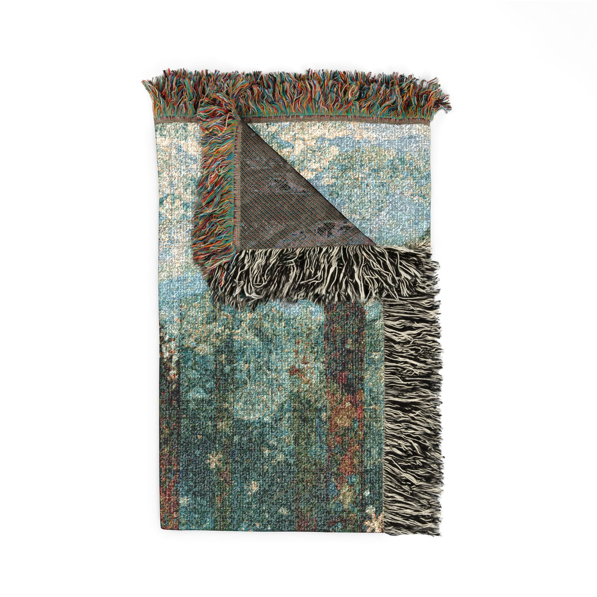 A rectangular woven throw blanket with fringed edges, shown flat against a white background. The top portion is folded back to reveal the reverse side, which has a dark charcoal gray patterned weave.
