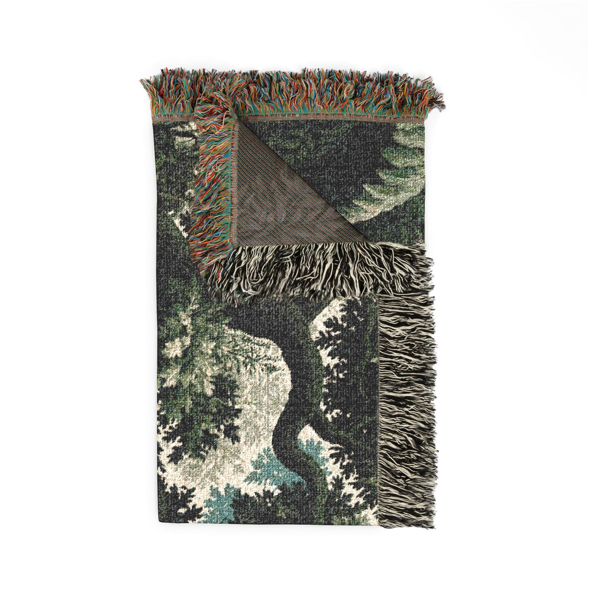 A rectangular woven throw blanket with a forest tree pattern in dark green, black, and cream, featuring multicolor fringe on all three sides, shown against a plain white background.
