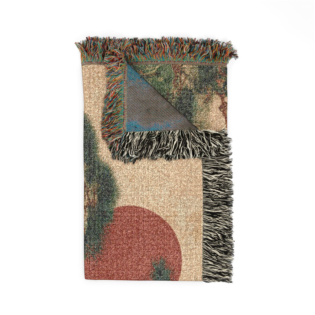 A folded woven throw blanket with multicolor abstract patterns, featuring a beige base, a large muted red semicircle, green and blue geometric accents, and dark gray fringe tassels.