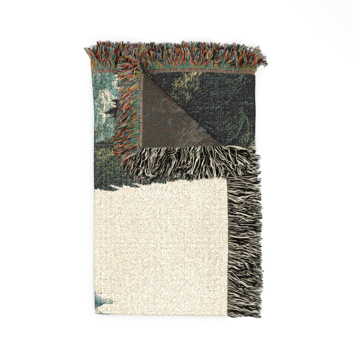 A rectangular woven throw blanket with fringed edges, shown flat on a white background. One corner is folded to reveal both sides: one side has a dark forest pattern, and the other side is a textured cream/off-white.