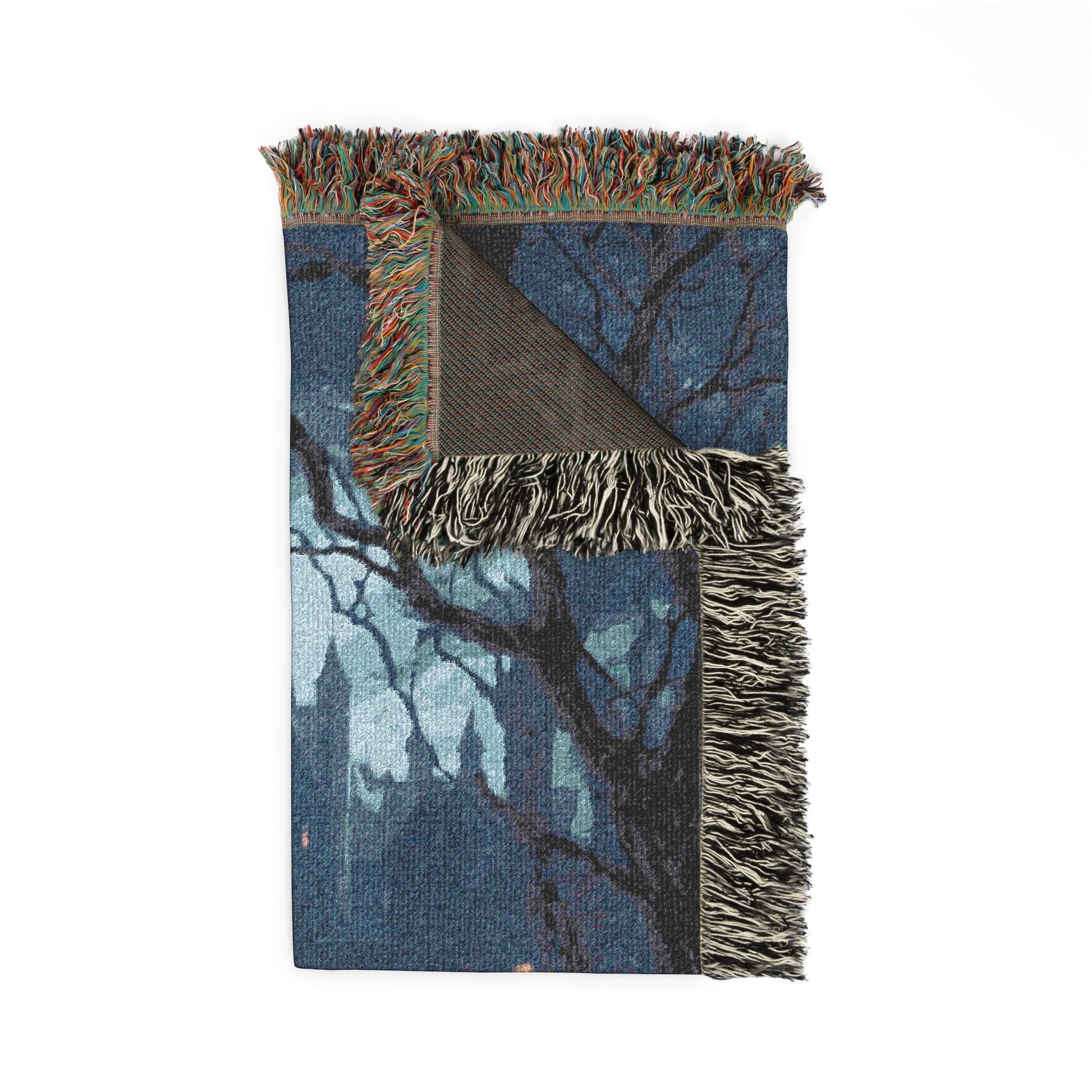 Woven blanket with tree design and fringed edge on a white background